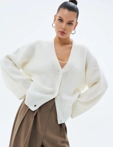Détail du cardigan blanc en maille avec de grands boutons et col en V profond