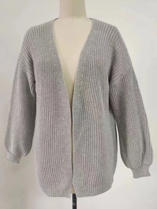 Detail of light grey chunky knit cardigan showing thick texture and ribbed cuffs