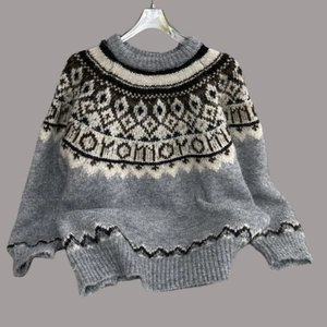 Detail of Fair Isle jacquard pattern on a soft gray knit sweater with geometric motifs