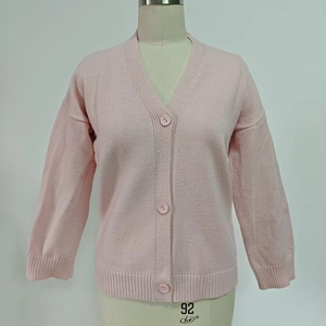 Détail du cardigan en maille rose avec col en V, poignets côtelés et boutons assortis