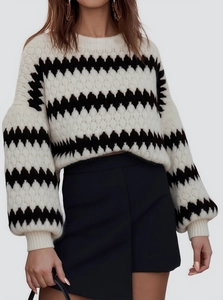 Detail of chunky knit sweater with black and white chevron pattern and lantern sleeves