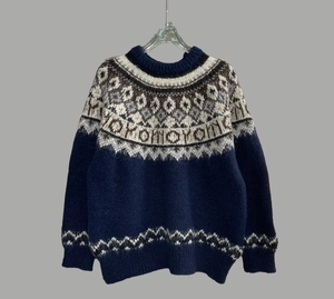 Close-up of Fair Isle snowflake jacquard pattern on a soft navy blue knit sweater