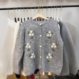 Gilet gris en maille avec broderie florale et boutons blancs en texture peluche