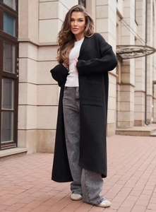 Dettaglio del lungo cardigan nero in maglia con due grandi tasche applicate e vestibilità