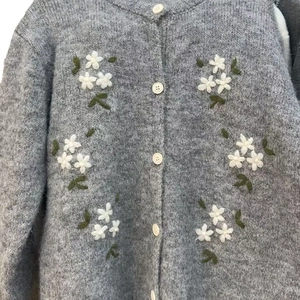 Cardigan en maille pelucheuse grise avec broderie florale blanche et boutonnage