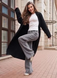 Stile street outdoor con lungo cardigan nero in maglia e jeans svasati in denim retrò