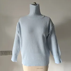 Macro shot of light blue high-neck knitted sweater featuring ribbed cuffs and soft texture