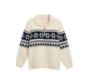 Detail of soft cream Fair Isle sweater with blue snowflake patterns and leather zipper pull