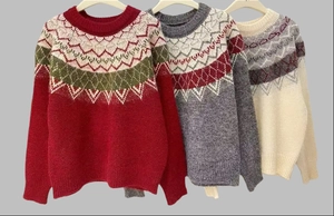 Close-up of Fair Isle geometric patterns on loose-fit Christmas knit sweaters in three colors