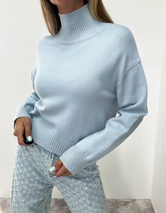 Detail of light blue high neck sweater showing ribbed cuffs and soft knit texture