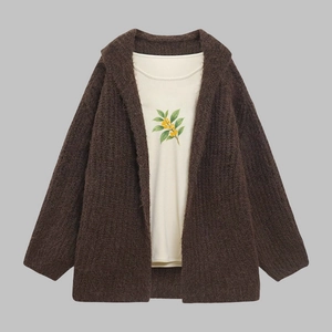 Detail of coffee brown knit cardigan with thick fuzzy texture and floral print inner tee