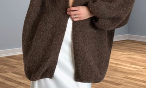 Detail of soft brown mohair knit cardigan paired with a white satin midi dress