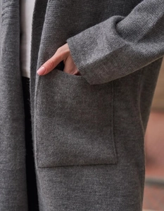 Dettaglio della tasca quadrata su un cardigan lungo grigio in maglia di lana testurizzata