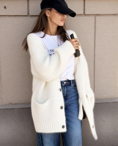 Detailed texture of white oversized knit cardigan with deep buttons and large pockets