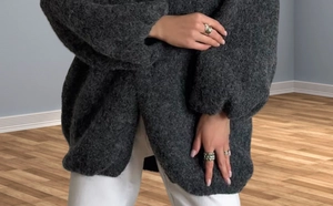 Close-up of soft dark grey knit cardigan with lantern sleeves and oversized texture