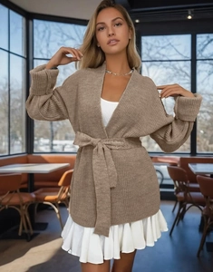 Detail of chunky knit brown cardigan featuring a waist belt and textured fabric