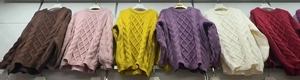 Detail of cable knit pattern and various color options for chunky crewneck sweaters