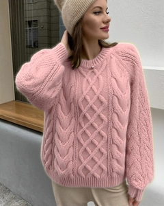 Detail of pink cable knit sweater with chunky diamond patterns and lantern sleeves