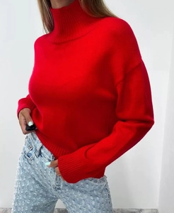 Close-up of red turtleneck sweater featuring wide ribbed cuffs and dropped shoulder seams