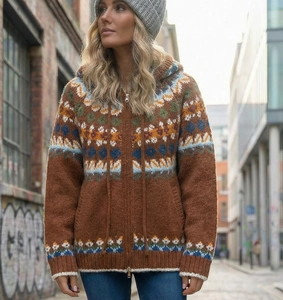 Detail view of Fair Isle pattern and metal zipper on brown hooded knit cardigan