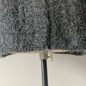 Detailed macro view of dark grey thick knit fabric with textured boucle wool finish