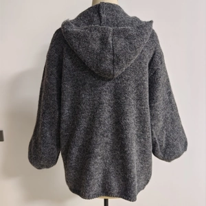 Detailed close-up of thick plush heather gray knit fabric on hooded oversized cardigan