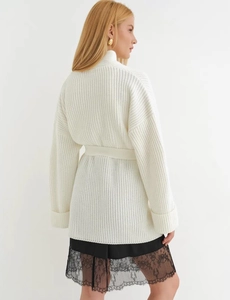 Detail of chunky knit texture and matching tie waist belt on cream cardigan