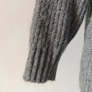 Macro shot of dark grey alpaca wool cardigan featuring ribbed knit cuffs and fuzzy texture