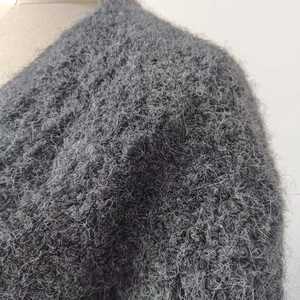 Macro shot showing soft dark grey long-fiber plush knit fabric and warm wool texture