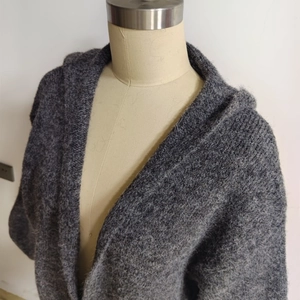 Close-up detail of grey marl knit fabric texture on a loose hooded cardigan
