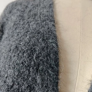 Detailed close-up of dark grey long plush knit cardigan with soft mohair texture