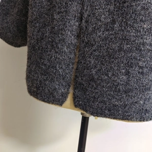 Detail of side slit design on dark grey oversized hooded knit cardigan for women