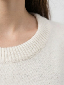 Minimalist cream crewneck knit sweater for women featuring a ribbed neckline and soft texture