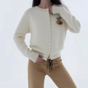 Minimalist cream knit cardigan with cherry accents and khaki pants in a casual style