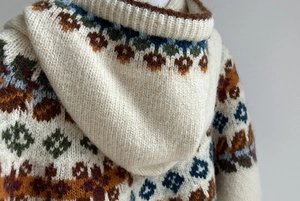Detailed macro view of the Fair Isle jacquard pattern and thick knit texture on the hoodie