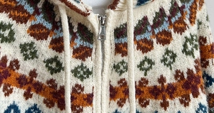 Close-up of Fair Isle knit cardigan detailing fiber texture and metal zipper