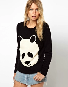 Detailed knit texture of black long sleeve sweater featuring a large panda head pattern