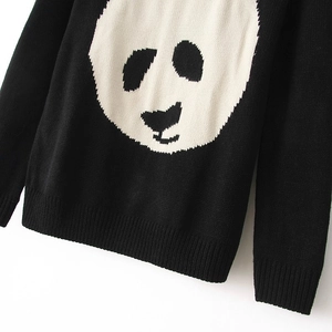 Close-up of knit texture and white panda face pattern on black crewneck sweater