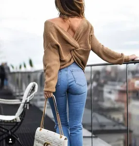Detail of camel V-neck knit sweater featuring a stylish twisted back cutout design