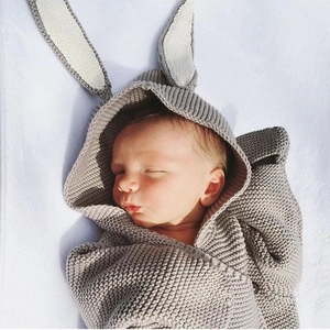 Knitted baby sleeping bag with cute rabbit ears in soft grey for cozy warmth