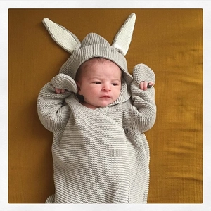 Detail of baby grey knit sleeping bag showing long rabbit ears and side button closure