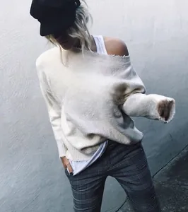 Détail du pull BLONDE blanc cassé avec bords effilochés et coupe à épaule dénudée