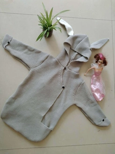 Detail of gray knitted baby romper with cute rabbit ears hood and button closure