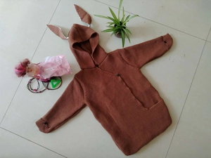 Detail of baby knitted hooded sleeping bag with cute rabbit ears and button closure