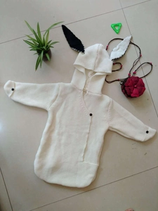 Detail of baby knitted sleeping bag featuring cute 3D animal ears and button closure