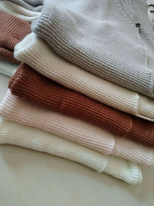 Macro shot of multi-color knitted baby blankets with textured fabric and dark buttons