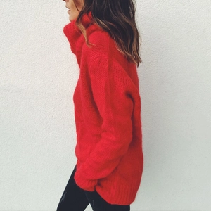 Detail of red oversized turtleneck sweater with thick knit texture and mohair finish