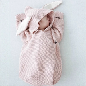 Cozy pink knitted baby sleeping bag with cute rabbit ears and button closure