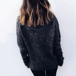 Detail view of charcoal grey chunky knit sweater featuring long sleeves and loose fit
