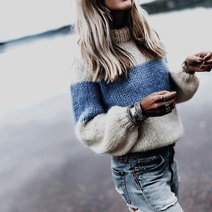 Detailed close-up of thick knit mohair sweater with color blocking and high neck design